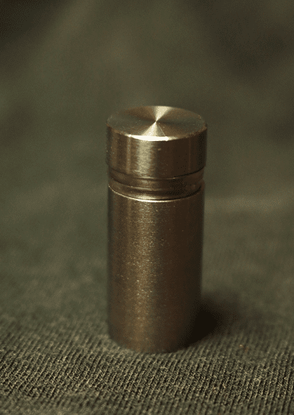 Image of standoff screw and barrel against dark background